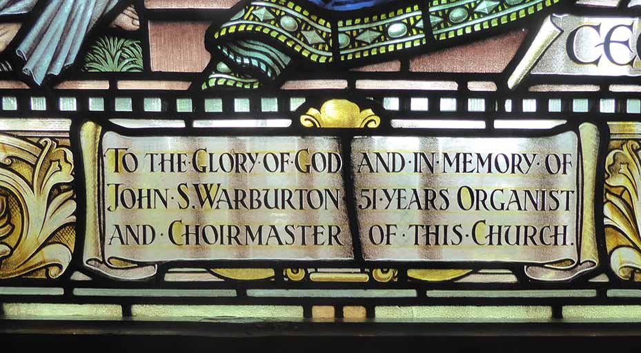 The dedication of the center window reads, "To the glory of God and memory of John S. Warburton 51 years organist and choirmaster of this church"