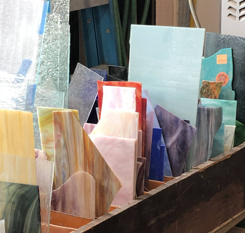 A long box with many divisions with colored glass partial sheets sticking up