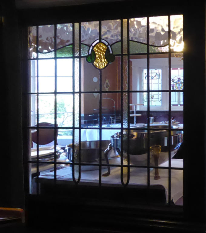 A simple but nicely divided leaded glass panel with a central shield design and mostly clear glass with a touch of green and gold glass